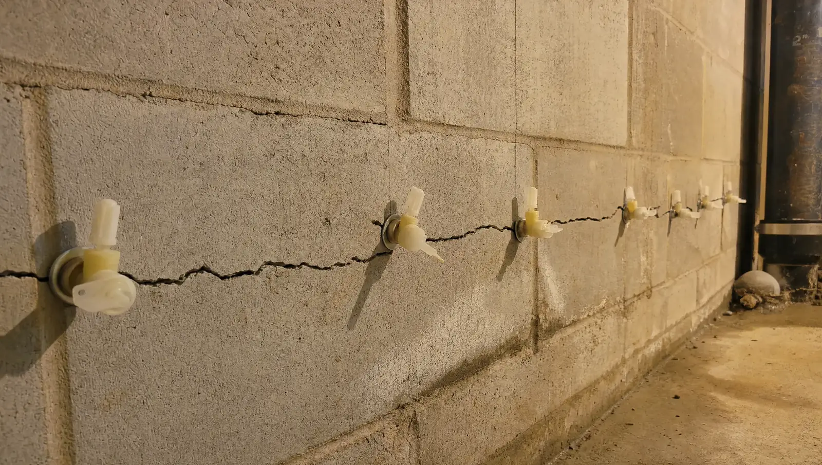 Basement crack repair Hamilton - injection port installation along horizontal crack in concrete wall